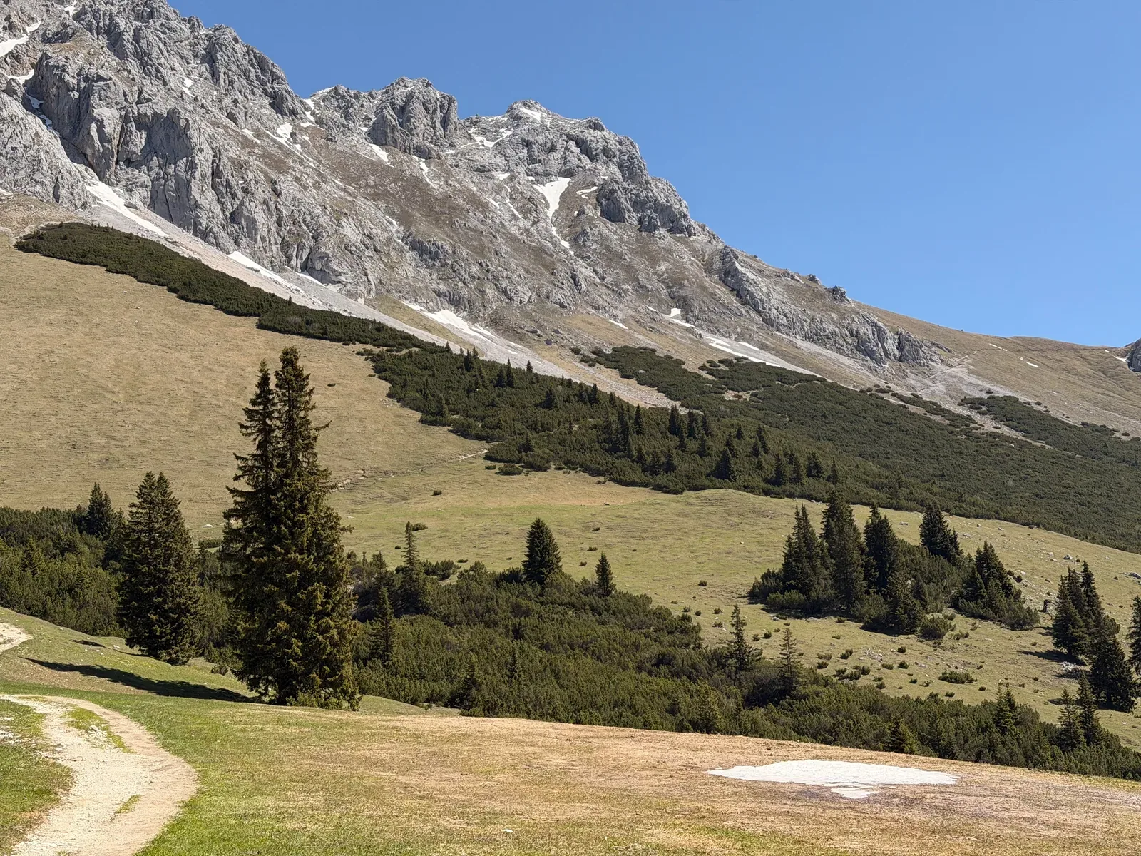 Open mountainside with gravel road and rock walls above Ehrwalder Alm, ZUT 107K at KM 28.