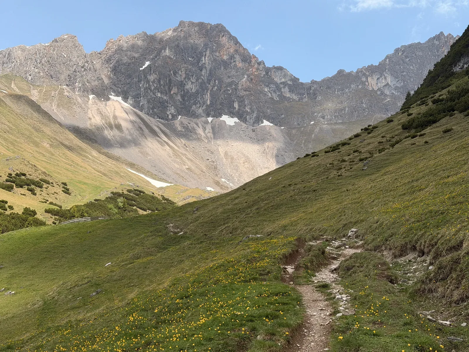 Singletrack across open alpine pasture with high Wetterstein walls, ZUT 107K at KM 45.1.