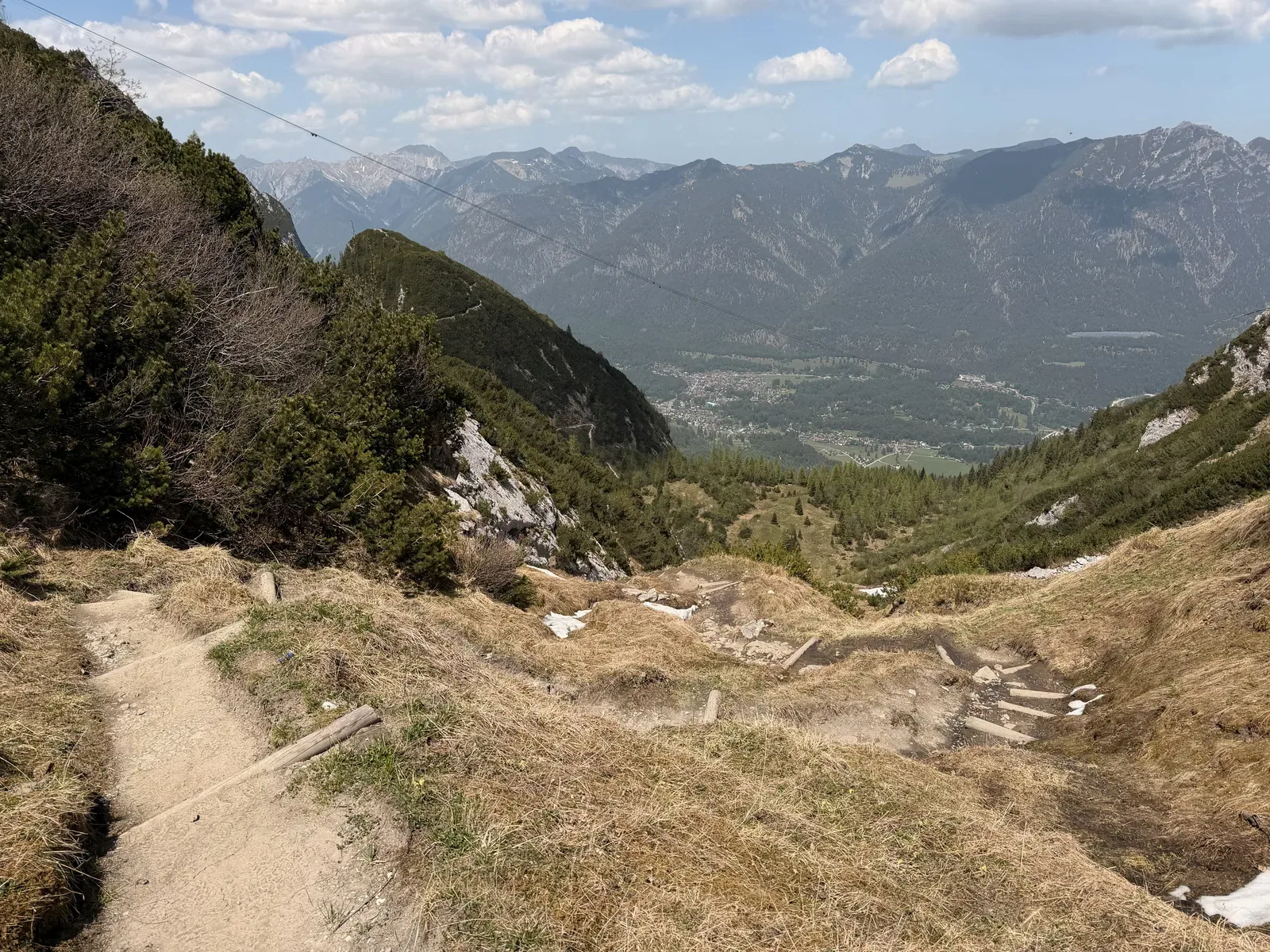 Steep gravel descent with valley views toward Garmisch-Partenkirchen, ZUT 107K at KM 93.7.